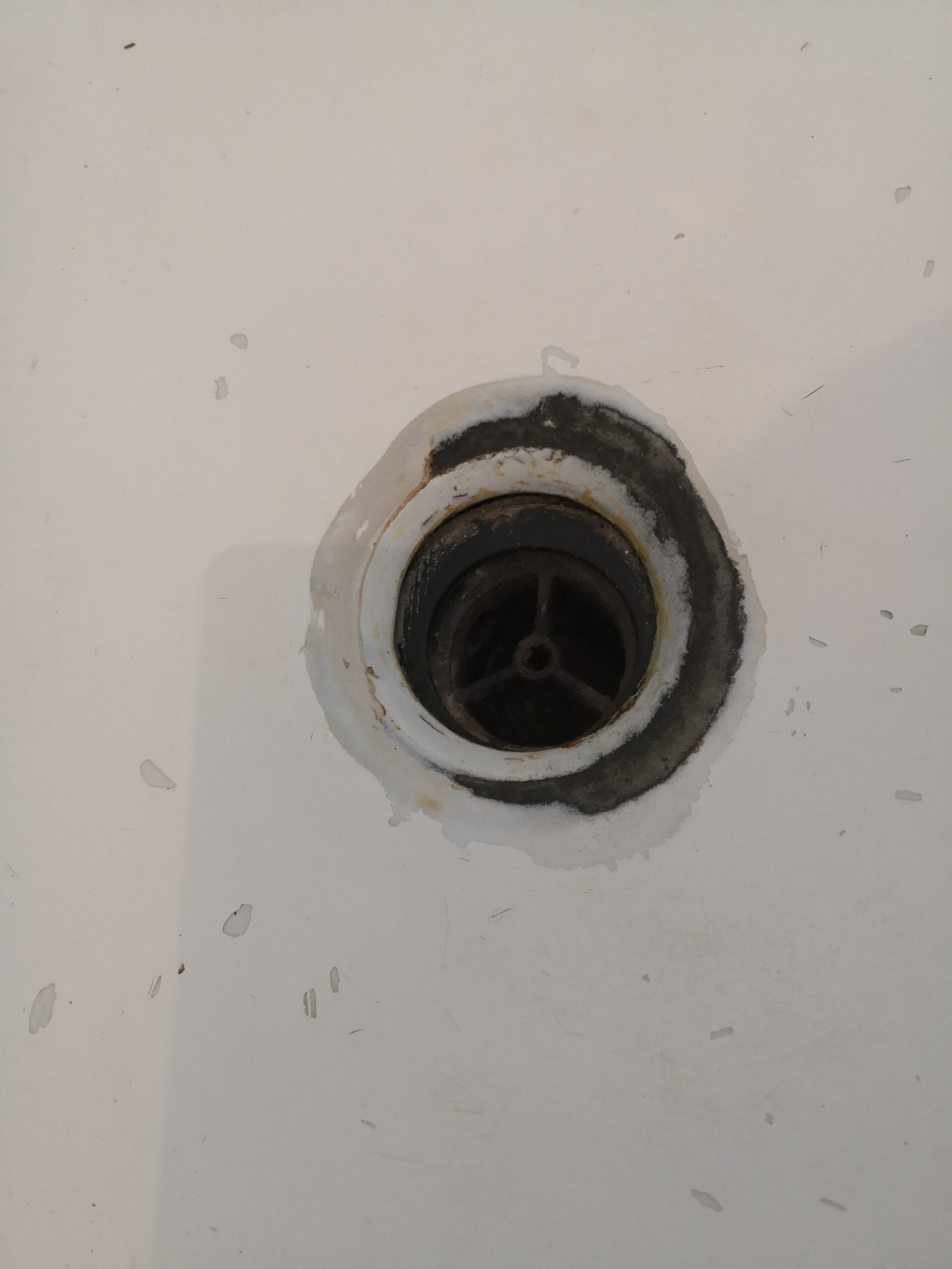 Bath re enamelling 11. Rusty Plug hole damage on re enamelled bath. close up. plug cleaned scaled
