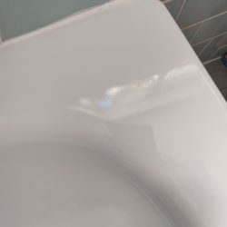 EB10 Chipped corner edge on metal bath. Repaired