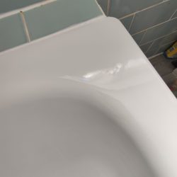 EB11 Chipped corner edge on metal bath. Repaired alt angle